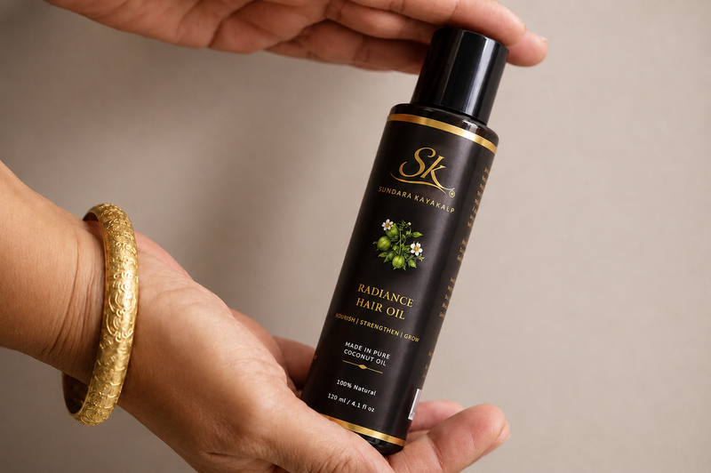 Shanthi Krishna holding the Radiance Hair Oil bottle. 